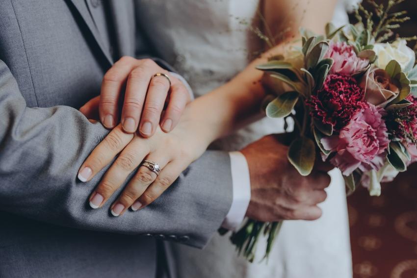 Bruid en bruidsgrom met trouwring linkerhand