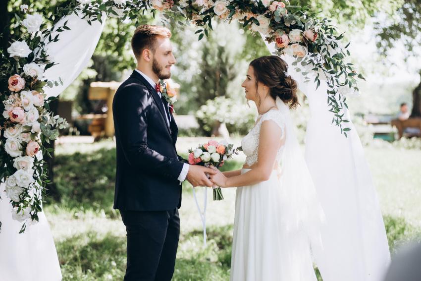 Paar onder een huwelijksboog - bloemen decoratie