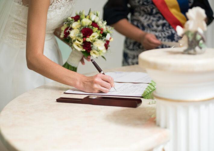 Bruid tekent voor de burgerlijke huwelijksceremonie